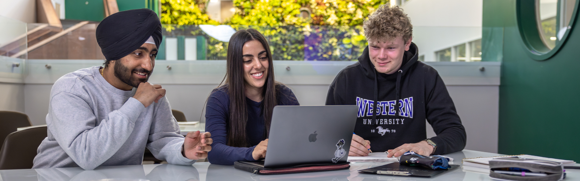 Three students working on coursework together in Thames Hall